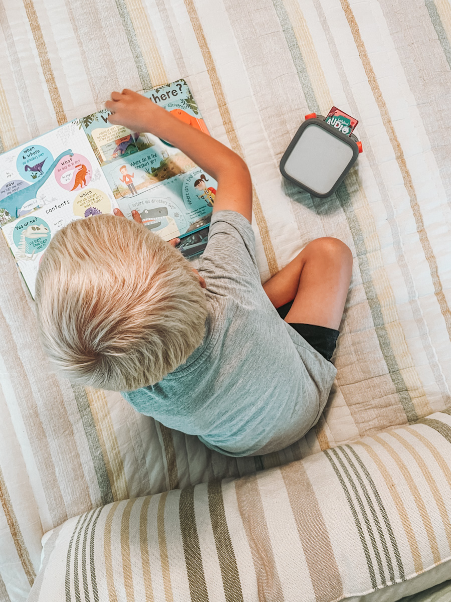 kid doing quiet time with books and a Yoto player for audiobooks