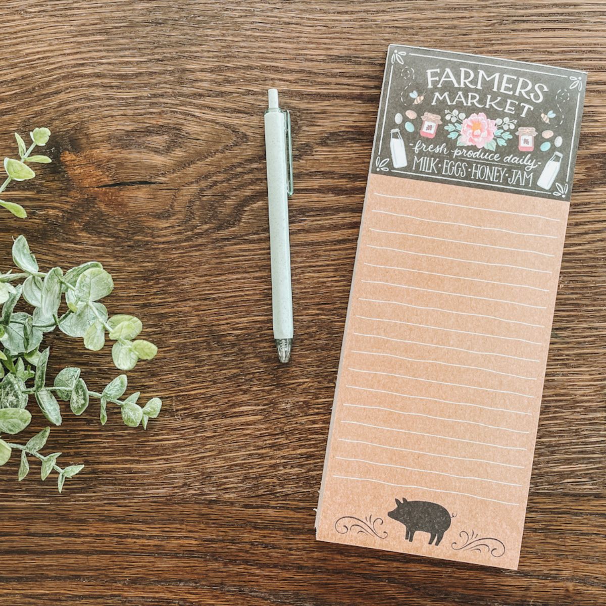 grocery paper laying on wood tabletop next to pen to create a meal plan