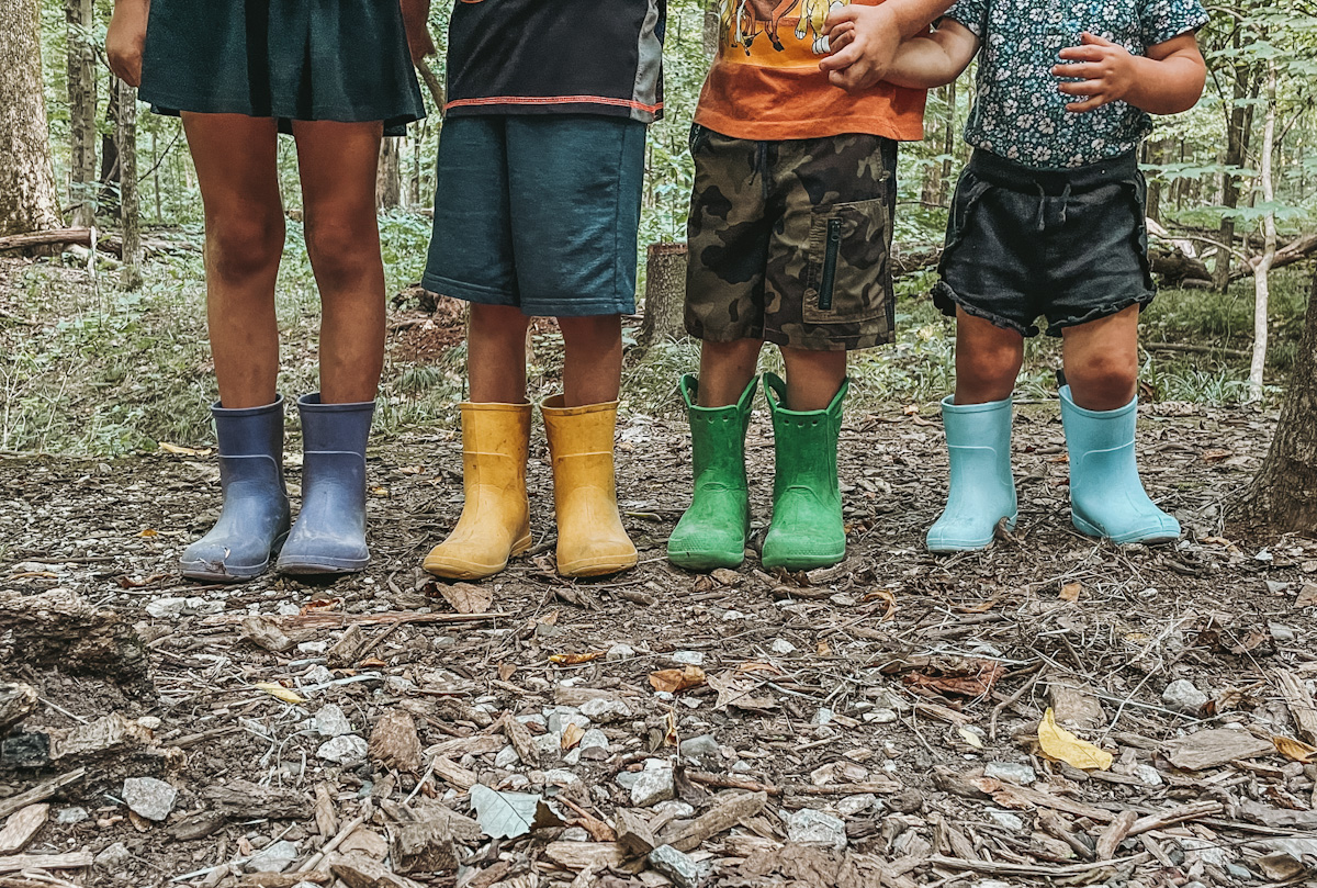 colorful mud boots on four kids as an outdoor essential for nature exploring