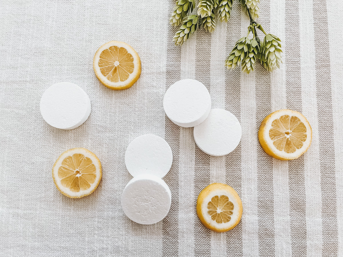 nontoxic toilet pods surrounded by lemon slices on a striped blanket